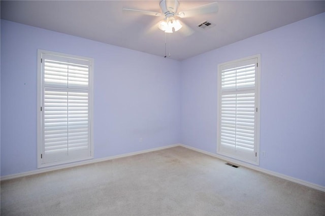 unfurnished room with ceiling fan, baseboards, carpet flooring, and visible vents