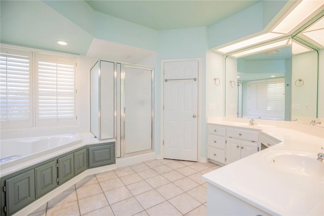 full bathroom featuring tile patterned floors, vanity, a garden tub, and a stall shower