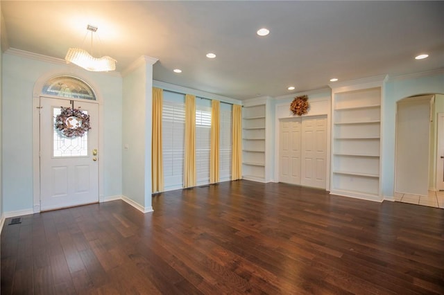 entryway featuring arched walkways, baseboards, ornamental molding, and hardwood / wood-style flooring