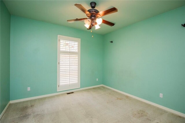 unfurnished room featuring carpet flooring, visible vents, baseboards, and ceiling fan