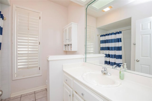 bathroom featuring vanity, toilet, curtained shower, tile patterned floors, and baseboards