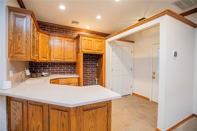kitchen with light countertops, visible vents, baseboards, and a sink