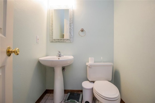 half bath featuring toilet and tile patterned flooring