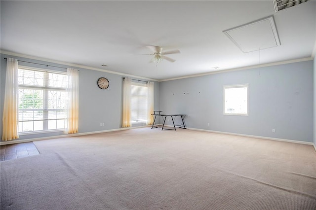 carpeted spare room with visible vents, baseboards, attic access, and ornamental molding