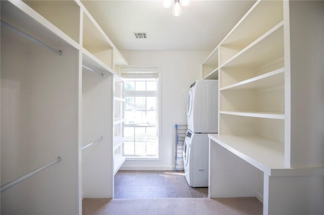 walk in closet with visible vents and stacked washer / drying machine