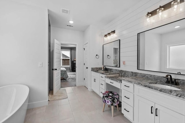 1241 Silver Maple St, Centerton, AR 72719 - full bathroom with double vanity, a freestanding tub, ensuite bathroom, baseboards, and tile patterned floors