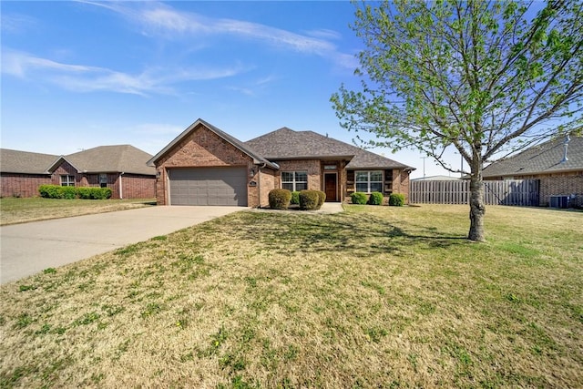 single story home with a front lawn, driveway, fence, brick siding, and a garage