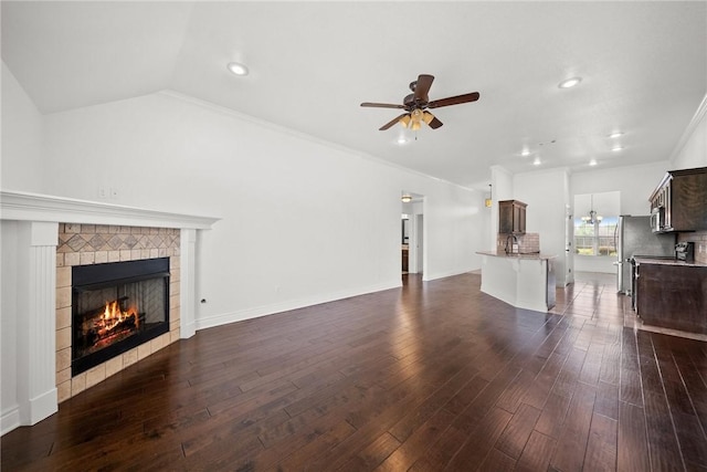 unfurnished living room featuring a sink, dark wood finished floors, recessed lighting, ceiling fan, and a fireplace