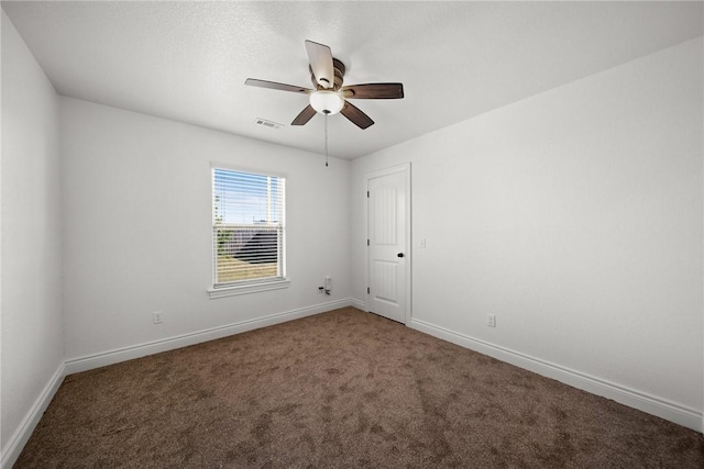 carpeted empty room with visible vents, a ceiling fan, and baseboards