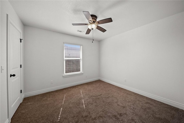 carpeted spare room featuring baseboards, a ceiling fan, and visible vents
