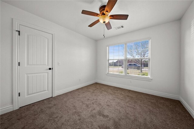 unfurnished room featuring baseboards, visible vents, carpet, and ceiling fan