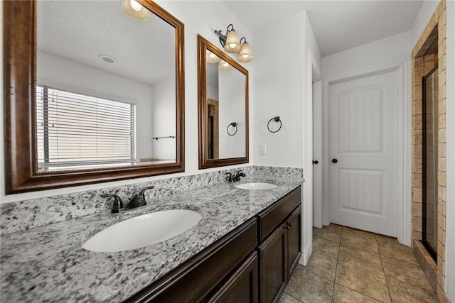 bathroom featuring double vanity, tile patterned flooring, a shower, and a sink