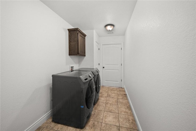 clothes washing area with light tile patterned flooring, cabinet space, baseboards, visible vents, and independent washer and dryer