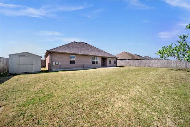 back of house with a storage shed, a yard, an outbuilding, and a fenced backyard