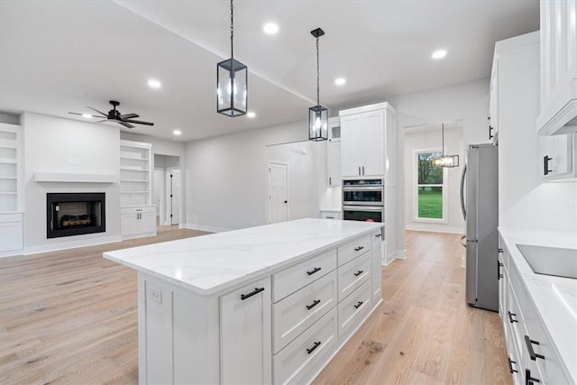 17153 Mill Hill Rd, Garfield, AR 72732 - kitchen featuring a center island, a ceiling fan, light wood-style floors, and appliances with stainless steel finishes