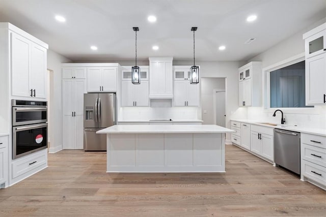 17153 Mill Hill Rd, Garfield, AR 72732 - kitchen featuring decorative backsplash, a kitchen island, a sink, white cabinets, and stainless steel appliances