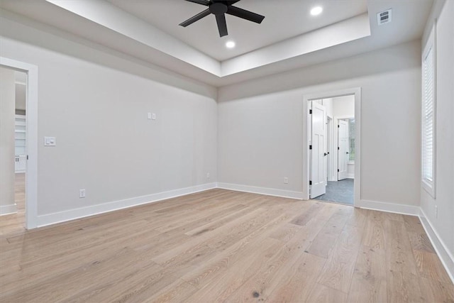 17153 Mill Hill Rd, Garfield, AR 72732 - spare room with visible vents, baseboards, light wood-type flooring, a tray ceiling, and a ceiling fan