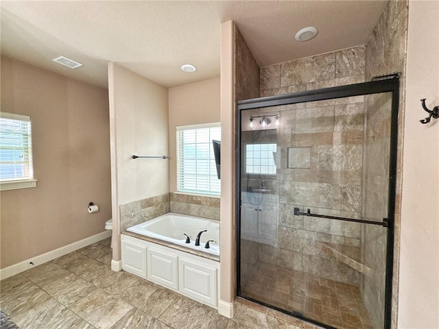 full bathroom with a shower stall, a garden tub, toilet, and plenty of natural light