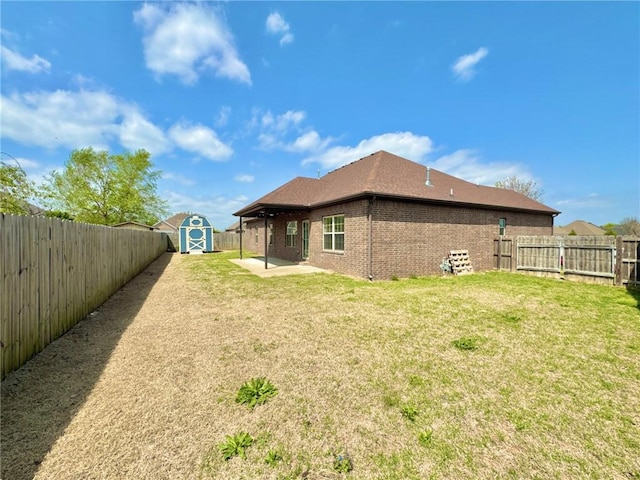 rear view of property with a fenced backyard, brick siding, a patio, and a storage shed