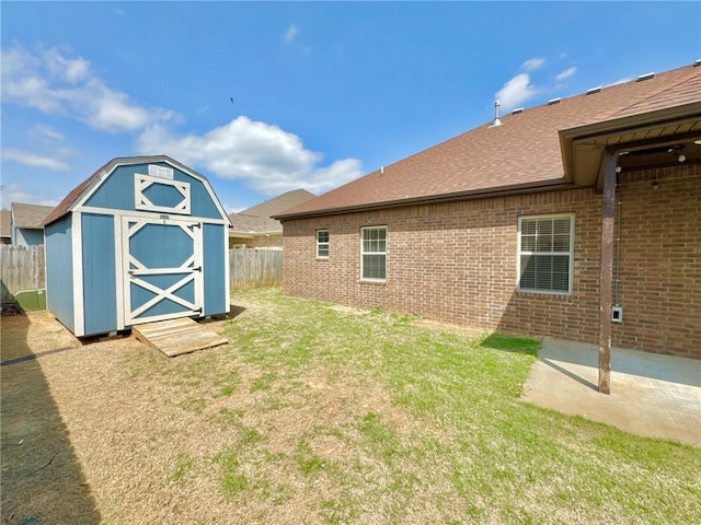 view of yard with fence, a patio area, a storage unit, and an outdoor structure