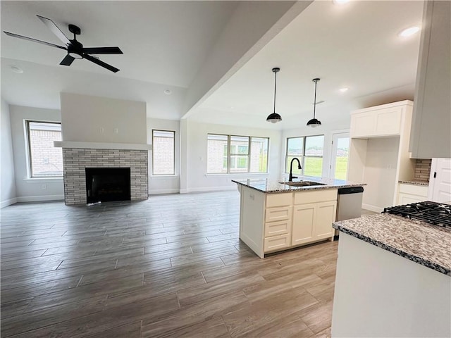6405 NW Harley St, Bentonville, AR 72713 - kitchen featuring dishwasher, light stone counters, white cabinets, lofted ceiling, and recessed lighting