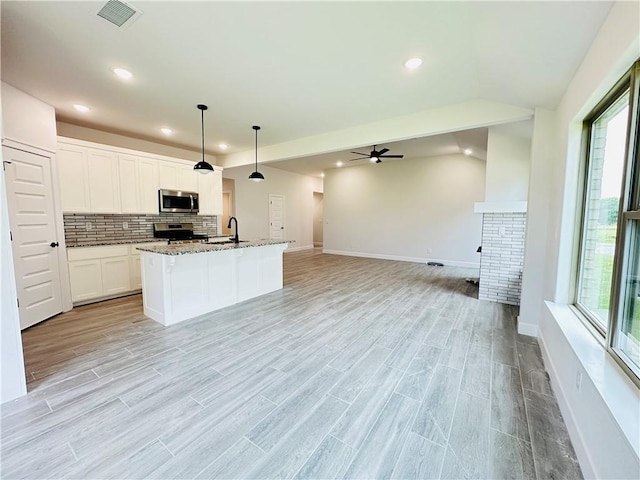 6405 NW Harley St, Bentonville, AR 72713 - kitchen featuring stainless steel microwave, range, recessed lighting, healthy amount of natural light, and ceiling fan