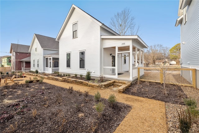 view of side of home featuring covered porch