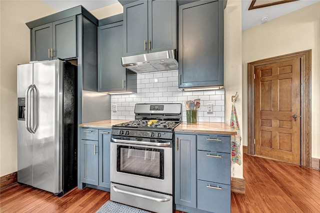 10093 Oklahoma Dr, Rogers, AR 72758 - kitchen featuring tasteful backsplash, under cabinet range hood, stainless steel appliances, light wood finished floors, and baseboards