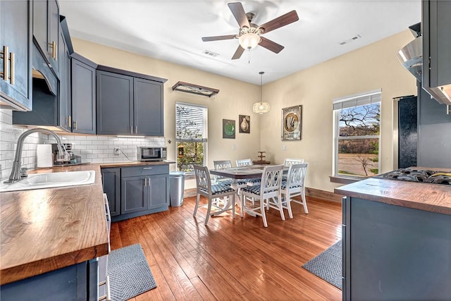 10093 Oklahoma Dr, Rogers, AR 72758 - kitchen with a sink, butcher block countertops, a wealth of natural light, and a ceiling fan