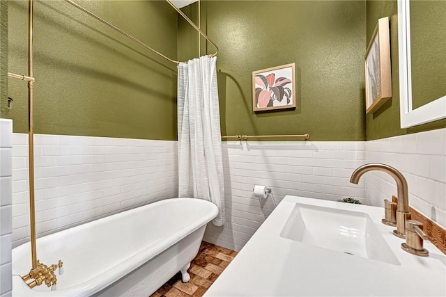 10093 Oklahoma Dr, Rogers, AR 72758 - bathroom featuring a sink, tile walls, a freestanding tub, and wainscoting