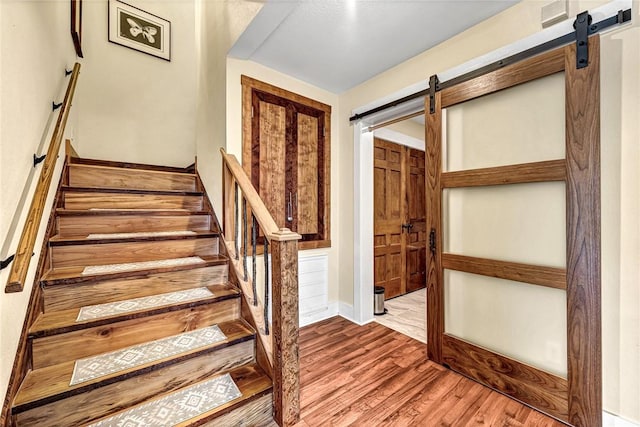 10093 Oklahoma Dr, Rogers, AR 72758 - staircase featuring a barn door, visible vents, and wood finished floors