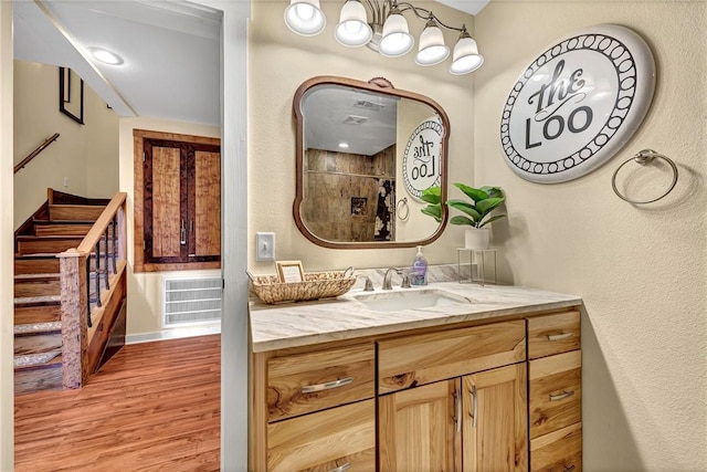 10093 Oklahoma Dr, Rogers, AR 72758 - full bath featuring visible vents, baseboards, vanity, wood finished floors, and tiled shower