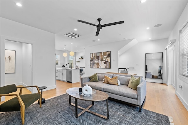 living room with light wood-style floors, a ceiling fan, visible vents, and recessed lighting