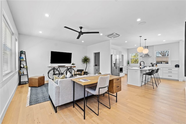 living area featuring recessed lighting, visible vents, light wood-type flooring, and a ceiling fan