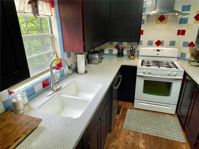 42 Vaughn St, Eureka Springs, AR 72632 - kitchen with white range with gas cooktop, a sink, backsplash, ventilation hood, and wood finished floors