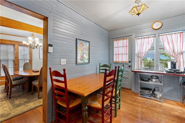 42 Vaughn St, Eureka Springs, AR 72632 - dining space featuring a chandelier, light wood finished floors, and wooden walls