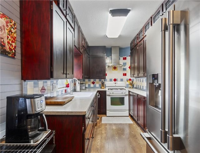 42 Vaughn St, Eureka Springs, AR 72632 - kitchen with stainless steel fridge with ice dispenser, white range with gas stovetop, island range hood, a sink, and light wood-type flooring