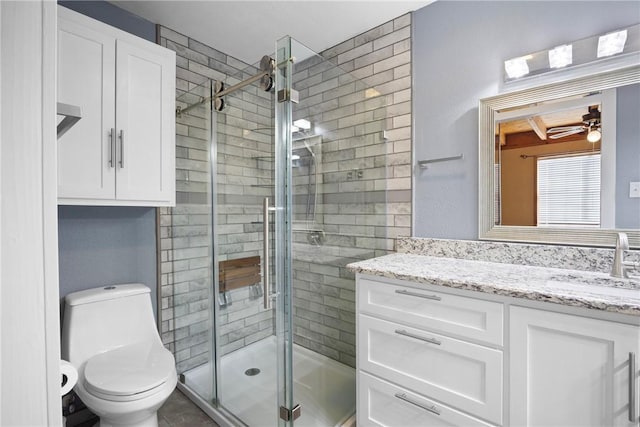 full bathroom featuring toilet, ceiling fan, a stall shower, and vanity