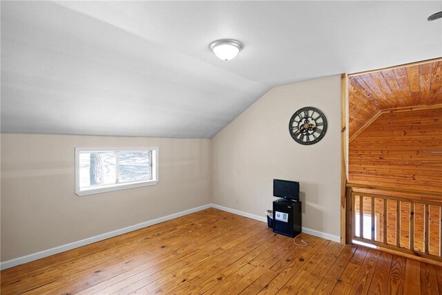 bonus room with baseboards, hardwood / wood-style flooring, and vaulted ceiling