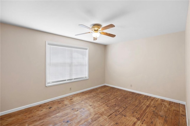 spare room with ceiling fan, wood-type flooring, and baseboards