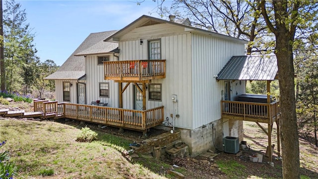 back of house with a deck, a shingled roof, cooling unit, and a balcony