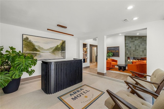 reception area featuring a tile fireplace and visible vents