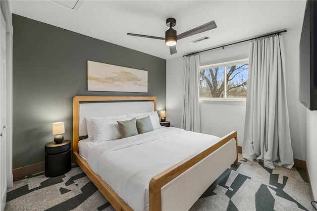 carpeted bedroom with visible vents, baseboards, and ceiling fan