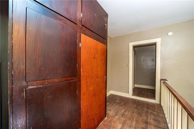 hallway featuring wood finished floors and baseboards