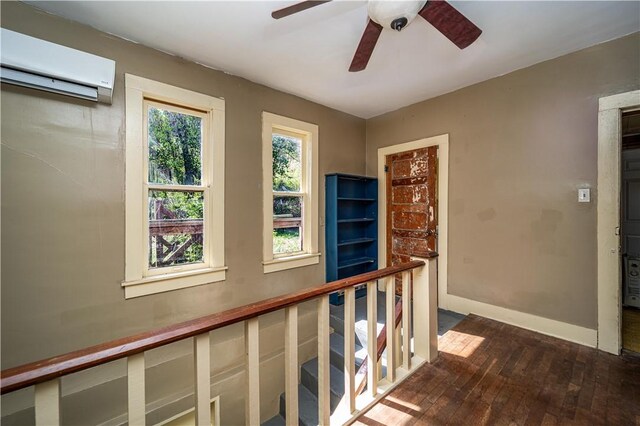 hall featuring baseboards, dark wood-style flooring, and a wall unit AC