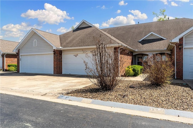 view of front of home with a garage, roof with shingles, brick siding, and concrete driveway