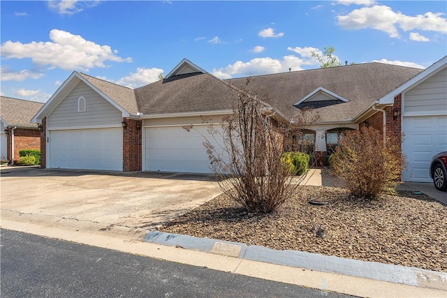 view of front facade featuring brick siding, an attached garage, a shingled roof, and concrete driveway