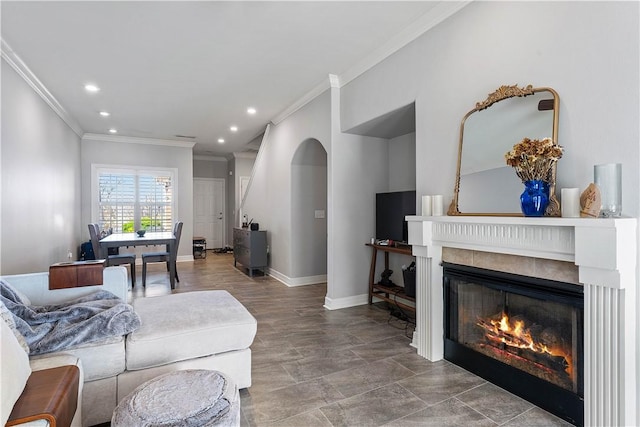 living room featuring crown molding, baseboards, a glass covered fireplace, and recessed lighting