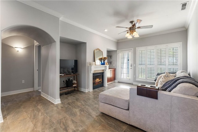 living room featuring ornamental molding, a ceiling fan, visible vents, stone finish flooring, and arched walkways