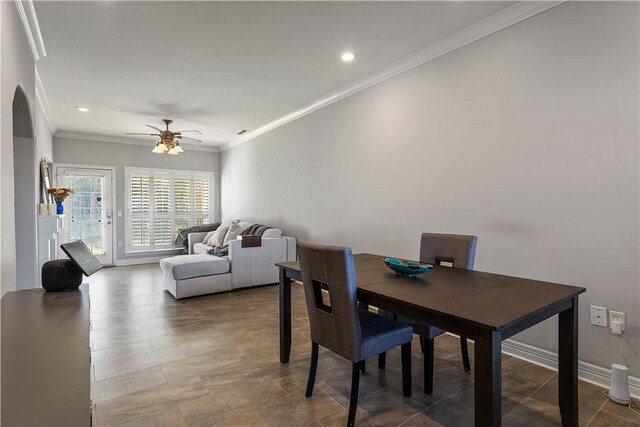 dining room featuring baseboards, arched walkways, ornamental molding, a ceiling fan, and recessed lighting